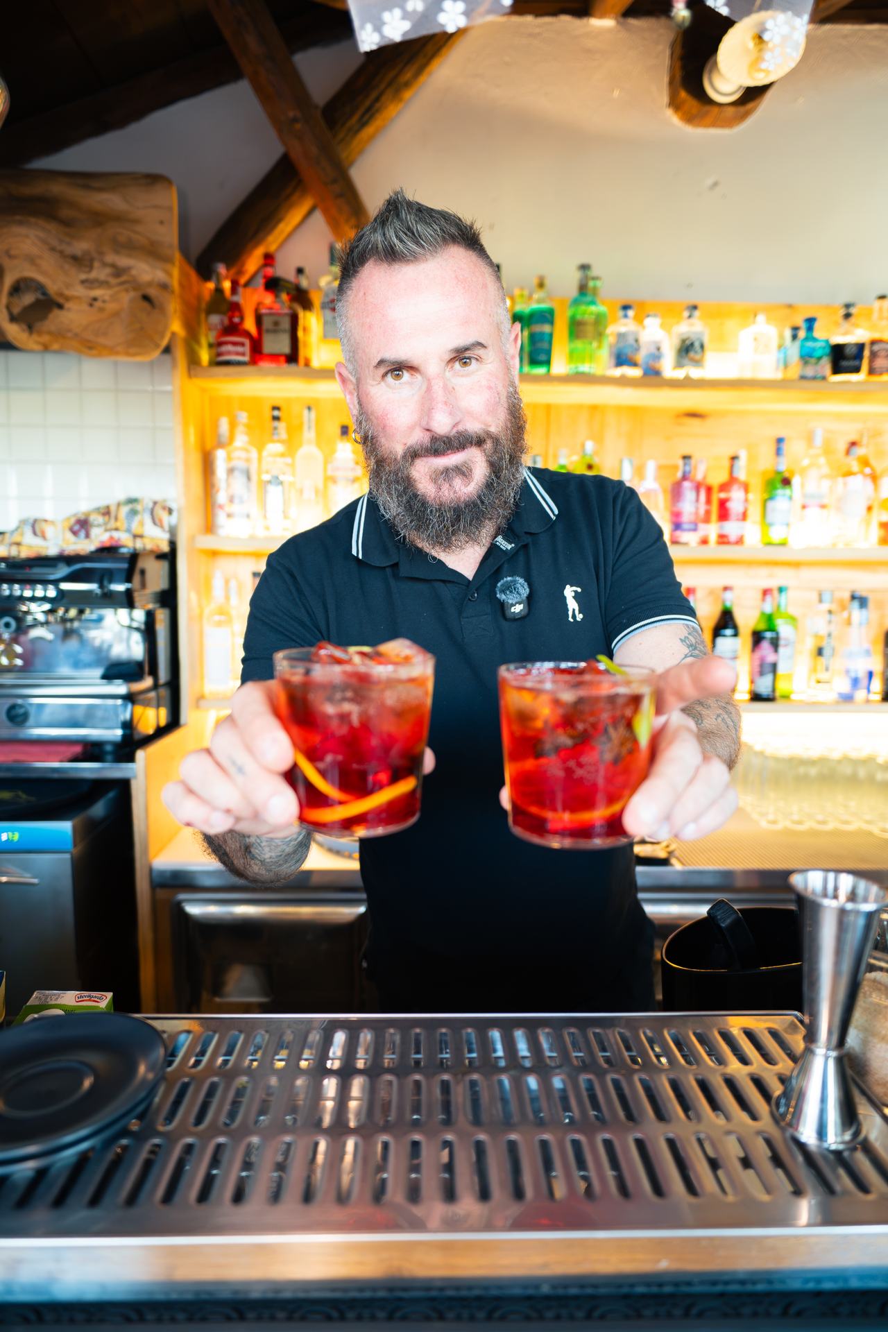 Il barman di Borgo 22 serve due cocktail al bancone